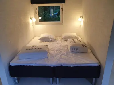 two beds in a small room with white sheets and pillows at Airbnb-lejligheder, Villerslev in Villerslev