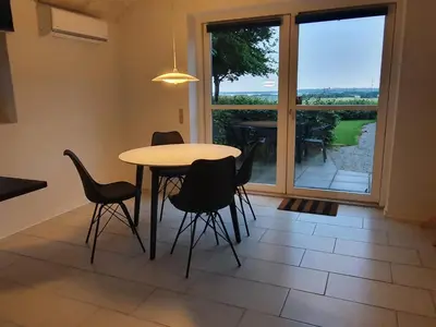 a dining room with a table and chairs and a window at Airbnb-lejligheder, Villerslev in Villerslev