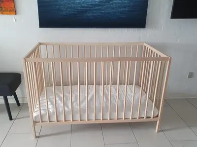 a crib with a white mattress in a room at Airbnb-lejligheder, Villerslev in Villerslev