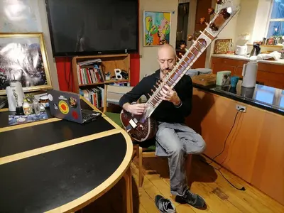 a man sitting on a chair playing a guitar at Thisted Øst Bed & No Breakfast in Thisted