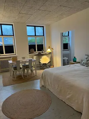 a bedroom with a bed and a table and chairs at Room 6 - Hawkraft Kulturhotel in Vestervig