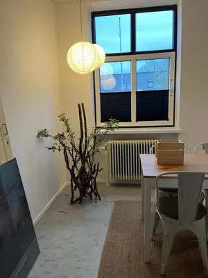 a living room with a table and a window at Room 6 - Hawkraft Kulturhotel in Vestervig