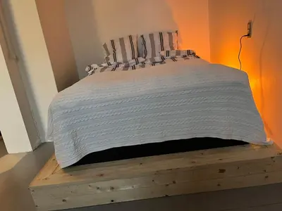 a bedroom with a bed with a wooden bed frame at Room 5 - Hawkraft kulturhotel in Vestervig