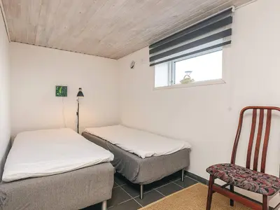 two beds in a room with a chair and a window at 4 person holiday home in Farsø-By Traum in Farsø