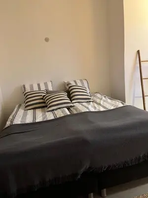 a bed with striped pillows in a bedroom at Room 4 - Hawkraft kulturhotel in Vestervig
