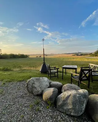 a park with two benches and a table and some rocks at Room 3 - Hawkraft kulturhotel in Vestervig