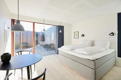 a bedroom with a bed and a table and a dining room at Vesterlandet in Vestervig