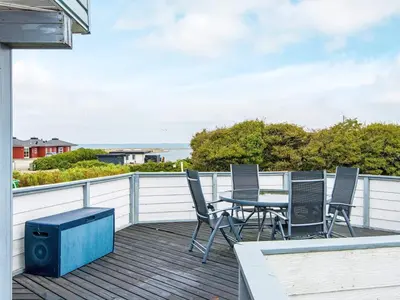 a patio with a table and chairs on a deck at 7 person holiday home in Lemvig-By Traum in Lemvig