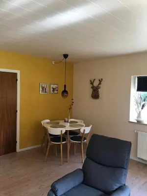 a living room with a table and a couch at Istrup gammel skole in Bedsted Thy
