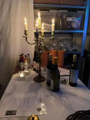 a table with bottles of wine and candles on it at Room 15 - Hawkraft kulturhotel in Vestervig