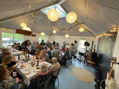 a group of people sitting at tables in a restaurant at Room 15 - Hawkraft kulturhotel in Vestervig