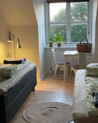 a living room with a couch and a table and a window at Room 16 - Hawkraft kulturhotel in Vestervig
