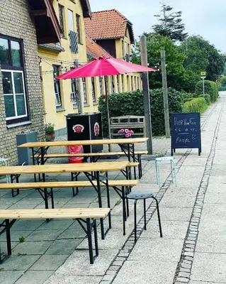 a picnic table with an umbrella on a sidewalk at Room 16 - Hawkraft kulturhotel in Vestervig