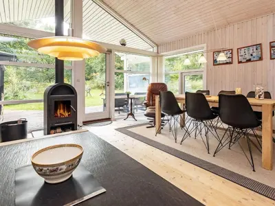 a living room with a fireplace and a table and chairs at 6 person holiday home in Farsø-By Traum in Farsø