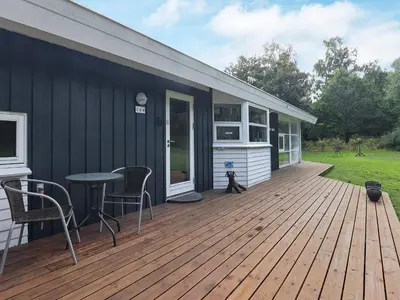 a house with a wooden deck with a table and chairs at 6 person holiday home in Farsø-By Traum in Farsø
