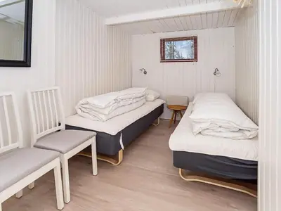 a room with two beds and a chair in it at 4 person holiday home in Thisted-By Traum in Thisted