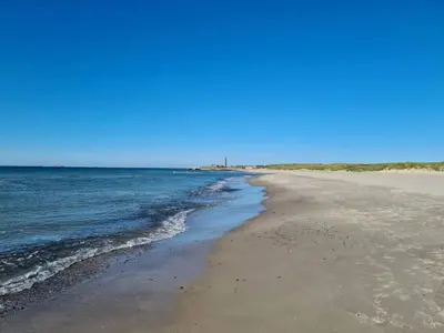 a sandy beach with the ocean on a clear day at 4 person holiday home in Thisted-By Traum in Thisted