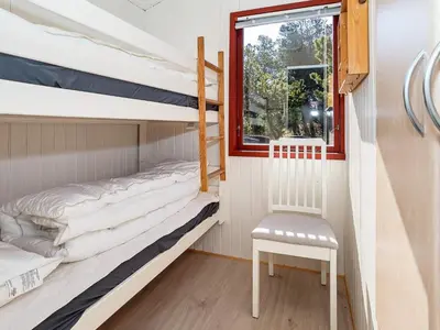 a bunk bed room with two bunk beds and a chair at 4 person holiday home in Thisted-By Traum in Thisted