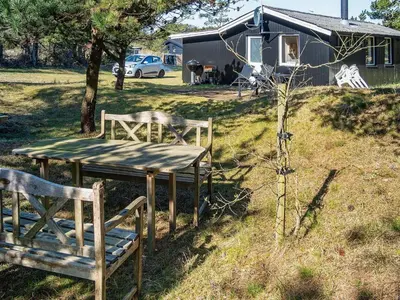 two wooden benches and a table in a field at 4 person holiday home in Thisted-By Traum in Thisted