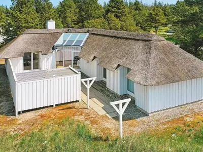 a large house with a thatched roof with a porch at 8 person holiday home in Fjerritslev-By Traum in Fjerritslev