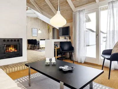 a living room with a table and a fireplace at 8 person holiday home in Fjerritslev-By Traum in Fjerritslev