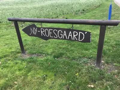a black sign that reads myrosland on a park bench at Ny Roesgaard in Lemvig