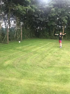 a young boy standing in a field with a frisbee at Ny Roesgaard in Lemvig