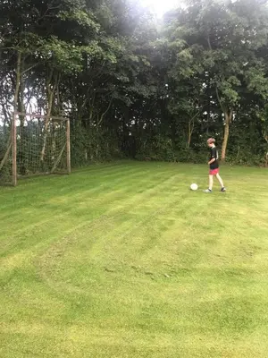 a young boy playing with a frisbee in a field at Ny Roesgaard in Lemvig