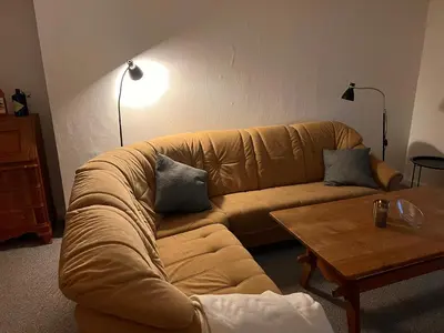 a living room with a couch and a coffee table at Hyggeligt byhus in Harboør