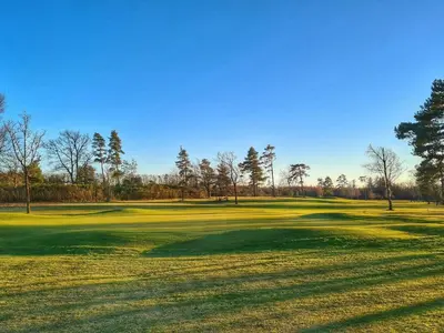 a view of a golf green with trees in the background at 6 person holiday home in Nibe-By Traum in Nibe