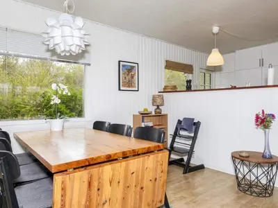 a dining room with a wooden table and chairs at 6 person holiday home in Nibe-By Traum in Nibe