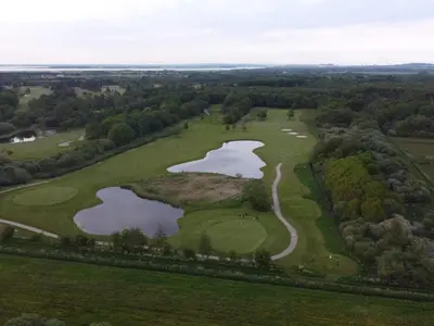 an overhead view of a golf course with two lakes at 6 person holiday home in Nibe-By Traum in Nibe