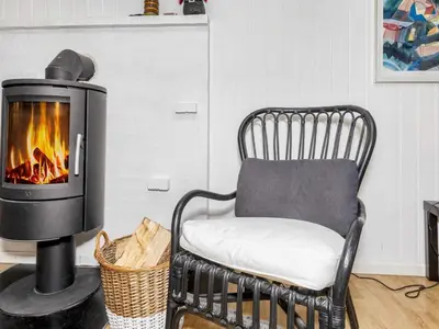 a fireside chair with a fireplace in a living room at 6 person holiday home in Nibe-By Traum in Nibe