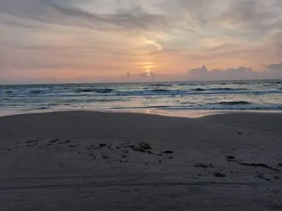 a sunset on a beach with the ocean at 6 person holiday home in Saltum-By Traum in Saltum