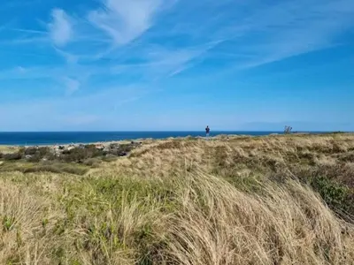 a person standing on a hill near the ocean at 6 person holiday home in Saltum-By Traum in Saltum
