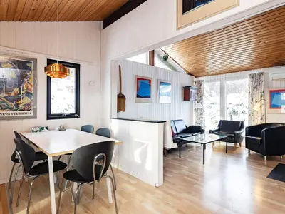 a dining room and living room with a table and chairs at 6 person holiday home in Saltum-By Traum in Saltum