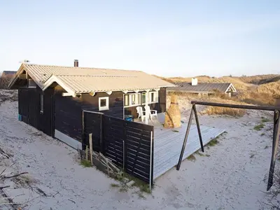 a small house with a deck in the sand at 6 person holiday home in Saltum-By Traum in Saltum