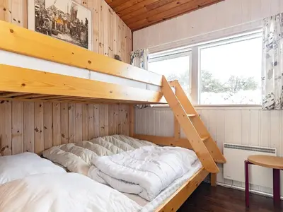 a bedroom with a bunk bed in a wooden room at 6 person holiday home in Saltum-By Traum in Saltum