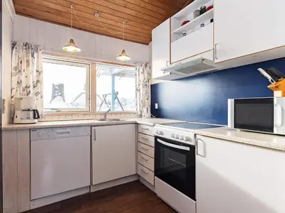 a kitchen with white appliances and a blue wall at 6 person holiday home in Saltum-By Traum in Saltum
