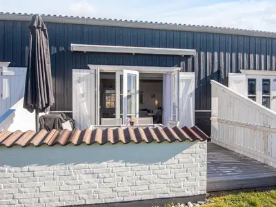 a building with a patio and an umbrella at 6 person holiday home in Vestervig-By Traum in Vestervig