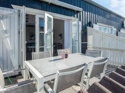 a wooden table and chairs on a deck at 6 person holiday home in Vestervig-By Traum in Vestervig