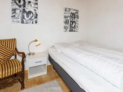 a bedroom with a bed and a chair and a lamp at 6 person holiday home in Bedsted Thy-By Traum in Bedsted Thy