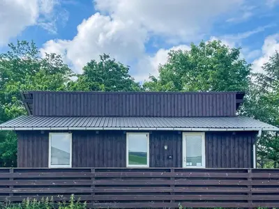 a house with a metal roof on top of a wooden fence at 6 person holiday home in Bedsted Thy-By Traum in Bedsted Thy