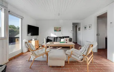 a living room with a table and chairs at 3 Bedroom Cozy Home In Blokhus in Blokhus
