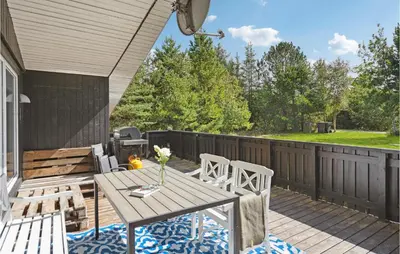 a patio with a wooden table and chairs at 3 Bedroom Awesome Home In Saltum in Saltum