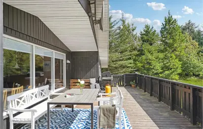 a patio with a table and chairs on a deck at 3 Bedroom Awesome Home In Saltum in Saltum