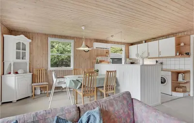 a kitchen and living room with a table and chairs at 3 Bedroom Awesome Home In Saltum in Saltum