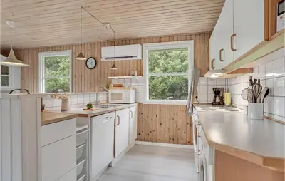 a kitchen with white appliances and wooden walls at 3 Bedroom Awesome Home In Saltum in Saltum
