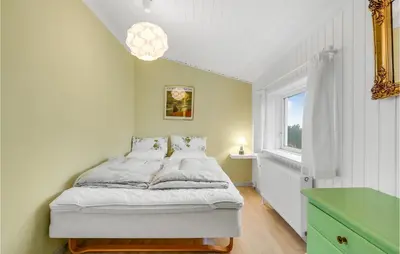 a small bedroom with a bed and a window at Stunning Home In Blokhus in Blokhus
