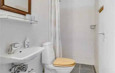 a white bathroom with a toilet and a sink at Stunning Home In Blokhus in Blokhus